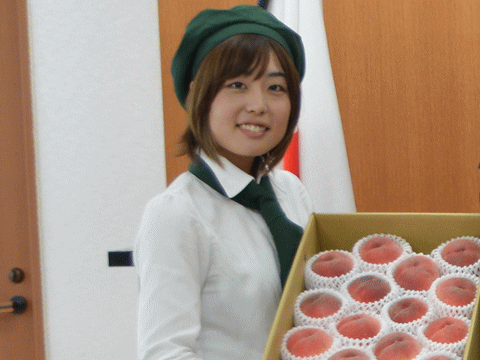 福島県知事にモモを贈る福島の綺麗な女性